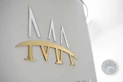 a metalmn sign on a wall with a clock at Millenium apartment in Soko Banja