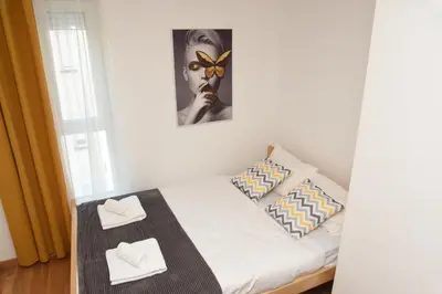 a small bedroom with a bed with two white towels at Millenium apartment in Soko Banja