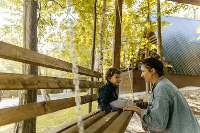 a woman and a child sitting on a park bench at Miletic Villas in Despotovac