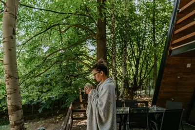 a woman in a robe looking at her cell phone at Miletic Villas in Despotovac