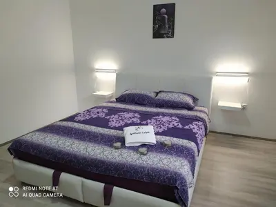 a bedroom with a purple bed with two pillows at Apartman Ljiljan in Soko Banja