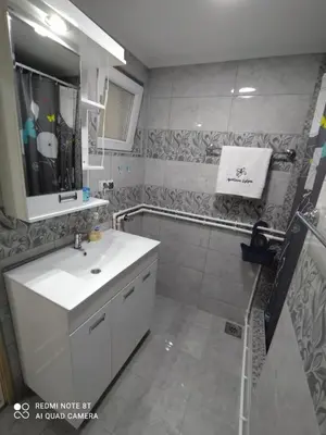 a bathroom with a white sink and a shower at Apartman Ljiljan in Soko Banja
