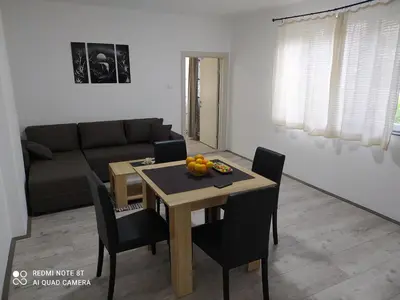 a living room with a table and a couch at Apartman Ljiljan in Soko Banja