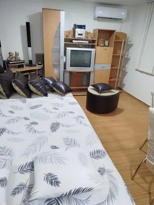 a bedroom with a bed with black and white sheets at Apartmani Strahinic in Leskovac