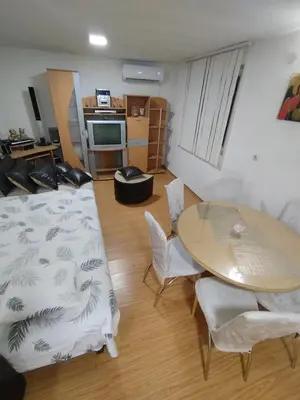 a living room with a table and a table and chairs at Apartmani Strahinic in Leskovac