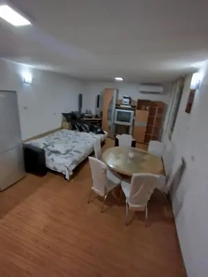 a room with a table and chairs and a bed at Apartmani Strahinic in Leskovac