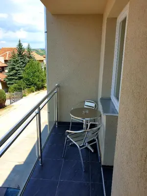 a table and a chair sitting on a balcony at Sokolux in Soko Banja