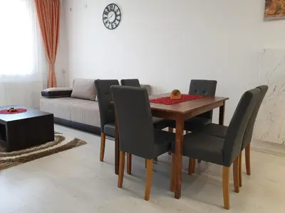 a dining room with a table and chairs and a couch at Sokolux in Soko Banja