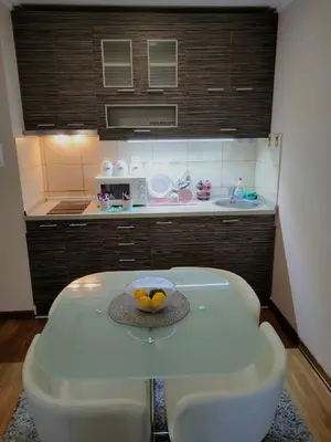a kitchen with a table with a bowl of fruit on it at Apartman Jovanovic in Vrnjačka Banja