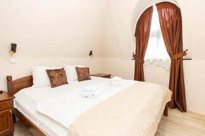 a bedroom with a white bed with a window at DOWNTOWN ROOMS in Niš