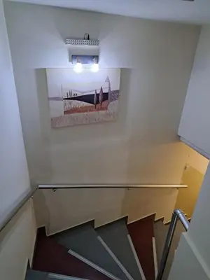a staircase with a picture on the wall at DOWNTOWN ROOMS in Niš