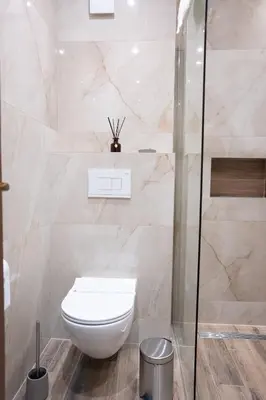 a bathroom with a toilet and a glass shower at DOWNTOWN ROOMS in Niš