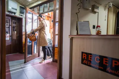 a man in a trench coat standing outside a restaurant at DOWNTOWN ROOMS in Niš
