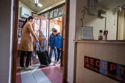a man holding a suitcase in front of a store at DOWNTOWN ROOMS in Niš