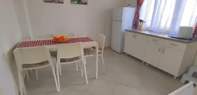 a kitchen with a table and chairs and a kitchen with a refrigerator at Kuća Veneto & Free Parking in Soko Banja