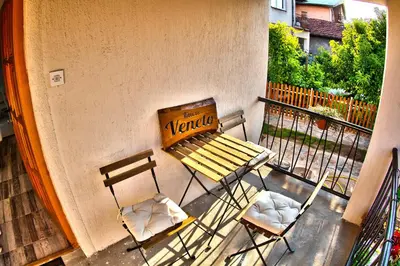 a bench and two chairs sitting on a balcony at Kuća Veneto & Free Parking in Soko Banja