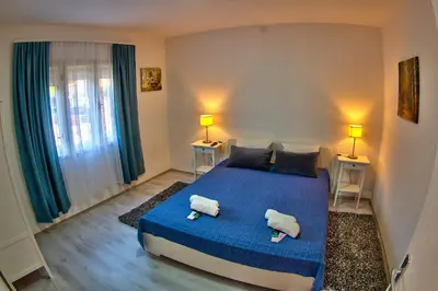 a bedroom with a blue bed with two towels on it at Kuća Veneto & Free Parking in Soko Banja
