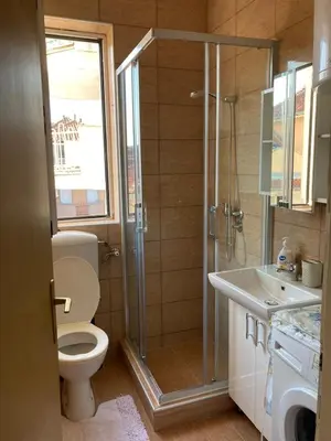 a bathroom with a shower and a toilet and a sink at Nina apartman in Vrnjačka Banja