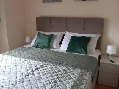 a bedroom with a large bed with green pillows at Nina apartman in Vrnjačka Banja