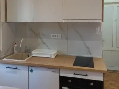 a kitchen with white cabinets and a sink at Nina apartman in Vrnjačka Banja