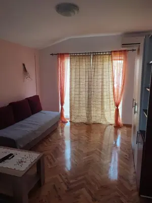 a living room with a couch and a wooden floor at Smeštaj Ćirković in Vrnjačka Banja