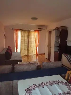 a living room with a couch and a large window at Smeštaj Ćirković in Vrnjačka Banja