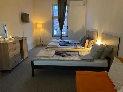 a bedroom with two beds and a dresser and a window at Stari Zaječar apartments in Zaječar