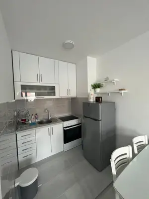 a kitchen with white cabinets and a stainless steel refrigerator at The View Apartment in Soko Banja