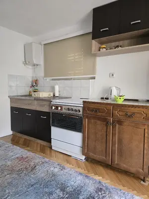 a kitchen with wooden cabinets and a white stove top oven at Apartman Stefanovic in Vrnjačka Banja