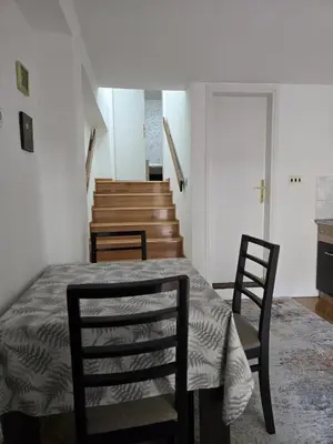 a room with a table and chairs and a staircase at Apartman Stefanovic in Vrnjačka Banja