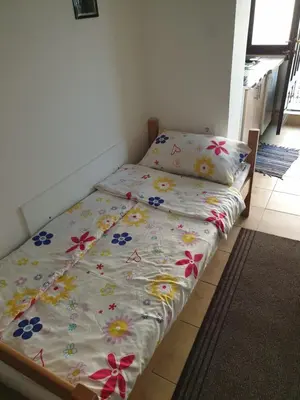 a bed in a room with flowers on it at Apartmani Mile in Soko Banja