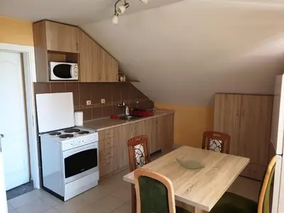 a kitchen with a table and a white stove top oven at Apartmani Mile in Soko Banja