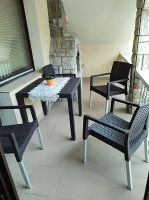 a porch with two chairs and a table and a window at Apartmani Mile in Soko Banja