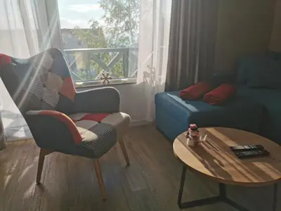 a living room with a chair and a table at Apartman Srebrna pahulja in Kopaonik