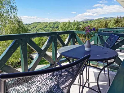 a table and chairs on a balcony with a view at Apartman Srebrna pahulja in Kopaonik