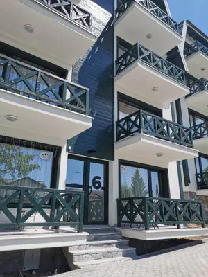 a house with a green and white facade at Apartman Srebrna pahulja in Kopaonik