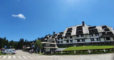 a large building with a green roof on a street at Apartments JAT Kopaonik in Kopaonik