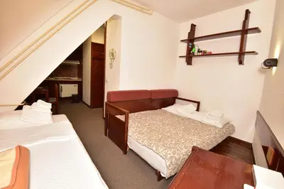 a small room with two beds and a staircase at Apartments JAT Kopaonik in Kopaonik