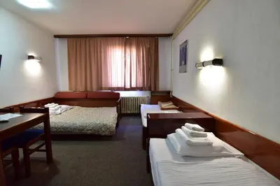 a hotel room with two beds and a table at Apartments JAT Kopaonik in Kopaonik
