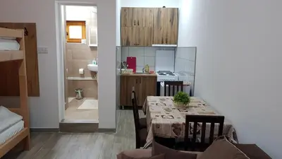 a kitchen and dining room with a table and a bathroom at Kuca Stojanovica Topli Do in Pirot