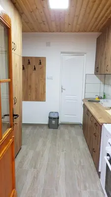 a kitchen with wooden floors and a white door at Kuca Stojanovica Topli Do in Pirot