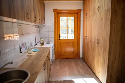 a kitchen with wooden cabinets and a wooden door at Kuca Stojanovica Topli Do in Pirot