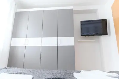 a bedroom with a bed and a tv on a wall at Panorama Lux in Soko Banja