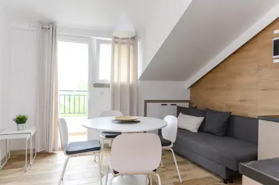 a living room with a couch and a table and chairs at Panorama Lux in Soko Banja