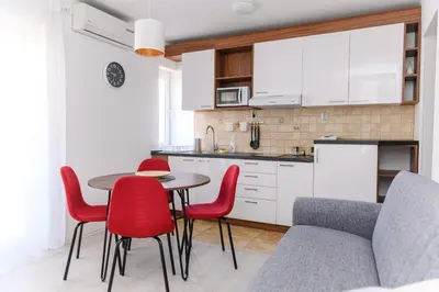 a kitchen with a table and some red chairs at Panorama Lux in Soko Banja