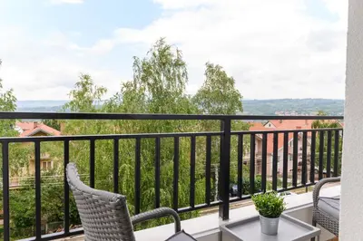 a balcony with two chairs and a table at Panorama Lux in Soko Banja