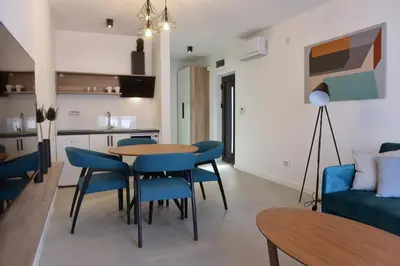 a living room with a table and chairs and a couch at 9 apartments in Jagodina