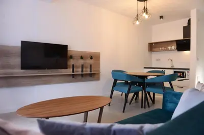 a living room with a table and chairs and a tv at 9 apartments in Jagodina