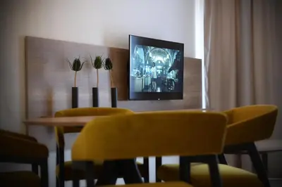 a dining room with a table and yellow chairs at 9 apartments in Jagodina