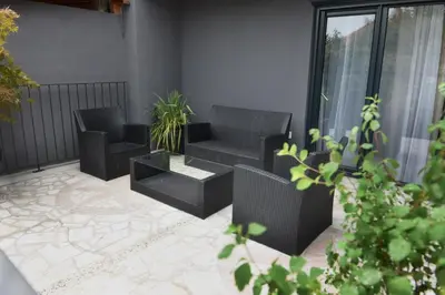 a patio with two chairs and a couch and a table at 9 apartments in Jagodina